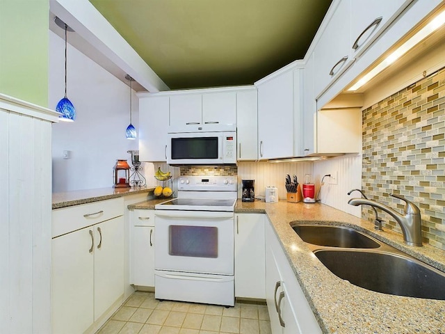 kitchen with decorative backsplash, light tile patterned flooring, white appliances, white cabinetry, and a sink