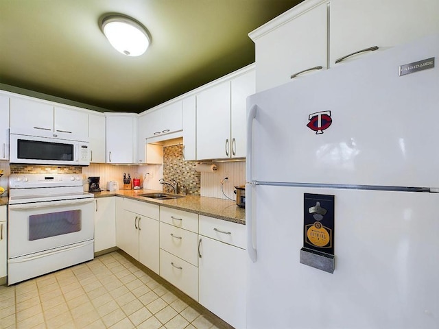 kitchen featuring white appliances, white cabinets, a sink, and tasteful backsplash