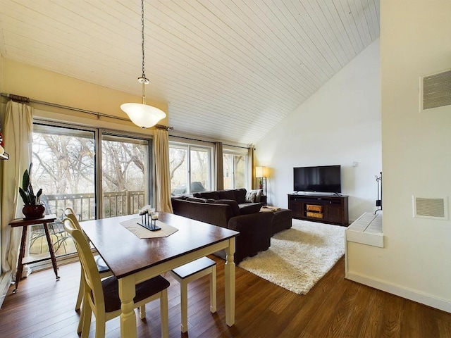 dining area featuring visible vents, dark wood finished floors, baseboards, and vaulted ceiling