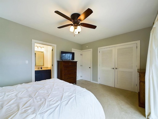carpeted bedroom with a ceiling fan, multiple closets, and ensuite bath