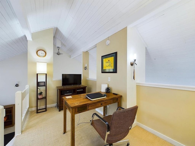 office area featuring baseboards, light carpet, and lofted ceiling