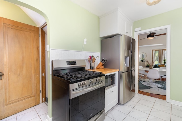 kitchen with appliances with stainless steel finishes, light tile patterned floors, white cabinets, a ceiling fan, and light countertops
