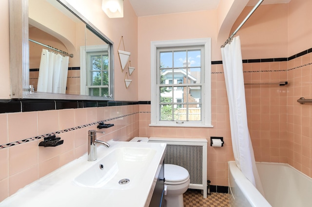 bathroom with tile walls, toilet, plenty of natural light, shower / bath combination with curtain, and vanity
