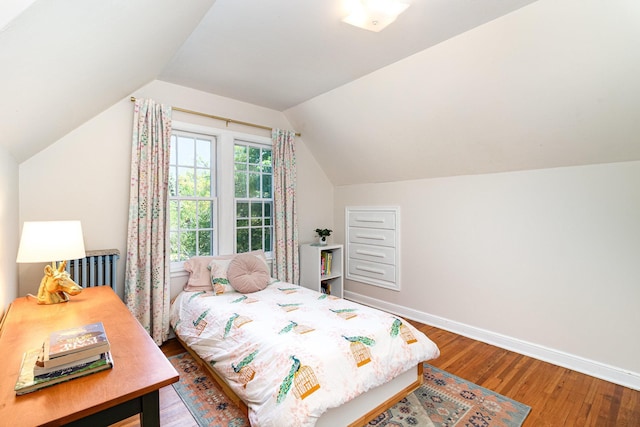 bedroom with wood finished floors, baseboards, and lofted ceiling