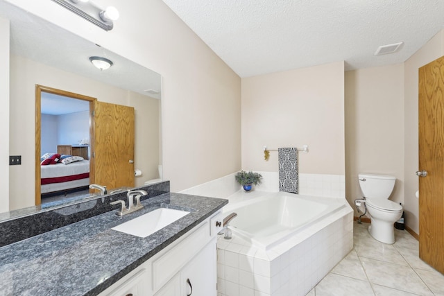 ensuite bathroom featuring a textured ceiling, a bath, tile patterned flooring, vanity, and toilet