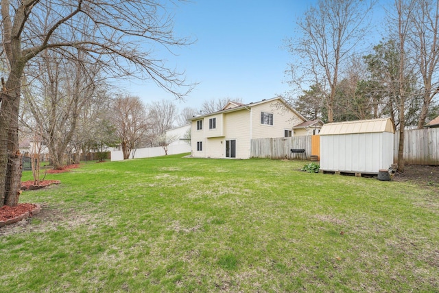 view of yard with an outbuilding, a fenced backyard, and a storage unit