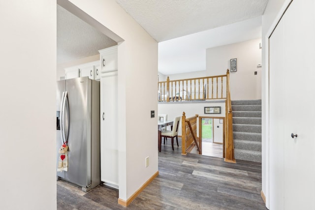 hall with baseboards, a textured ceiling, dark wood-style flooring, and stairway