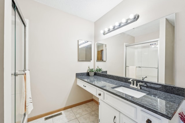 full bathroom featuring visible vents, vanity, baseboards, tile patterned floors, and a shower stall
