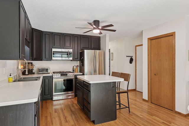 1283 Bidwell St, West Saint Paul, MN 55118 - kitchen featuring stainless steel appliances, a breakfast bar, a sink, and light wood-style floors