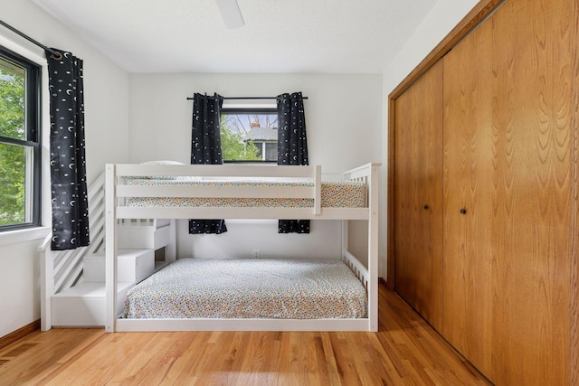 1283 Bidwell St, West Saint Paul, MN 55118 - unfurnished bedroom with multiple windows, wood finished floors, a closet, and baseboards