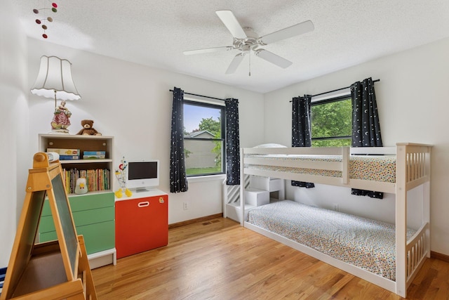 1283 Bidwell St, West Saint Paul, MN 55118 - bedroom with multiple windows, wood finished floors, a textured ceiling, and baseboards
