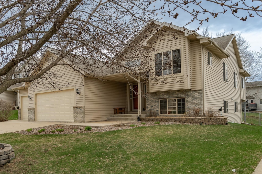 4434 Arcon Ln NW, Rochester, MN 55901 - tri-level home with a front yard, driveway, a garage, and brick siding