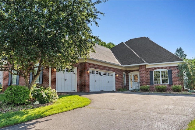 2228 White Pine Ct, Hudson, WI 54016 - view of front of home featuring an attached garage, brick siding, asphalt driveway, and roof with shingles