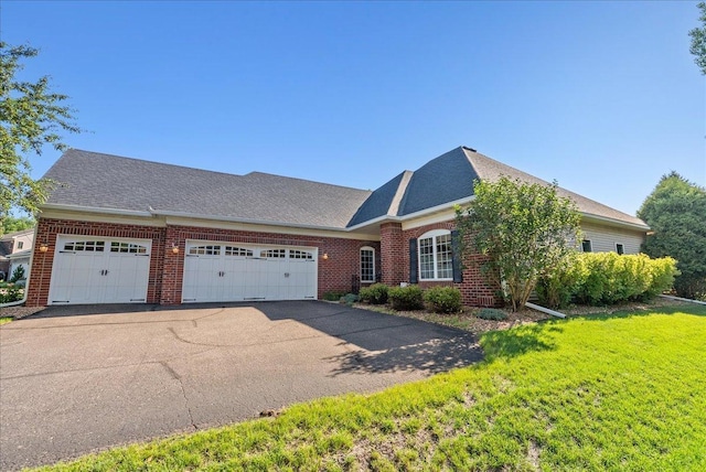 2228 White Pine Ct, Hudson, WI 54016 - view of front of house with brick siding, a garage, asphalt driveway, and a front yard