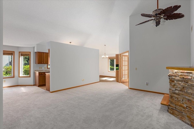 2228 White Pine Ct, Hudson, WI 54016 - unfurnished living room with a chandelier, light carpet, healthy amount of natural light, high vaulted ceiling, and a ceiling fan
