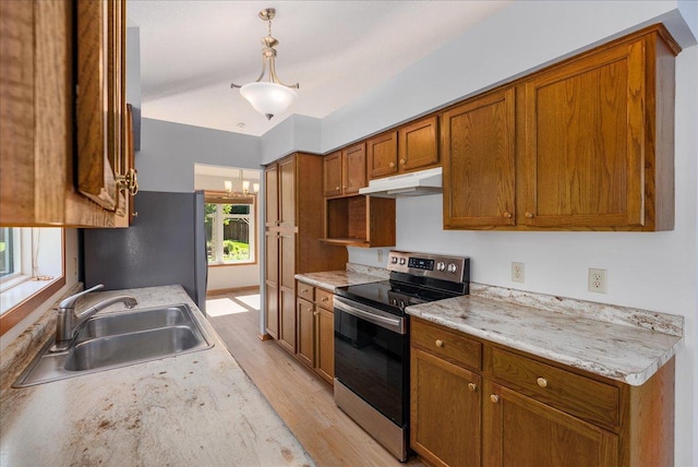 2228 White Pine Ct, Hudson, WI 54016 - kitchen with stainless steel electric stove, under cabinet range hood, freestanding refrigerator, light wood finished floors, and brown cabinetry