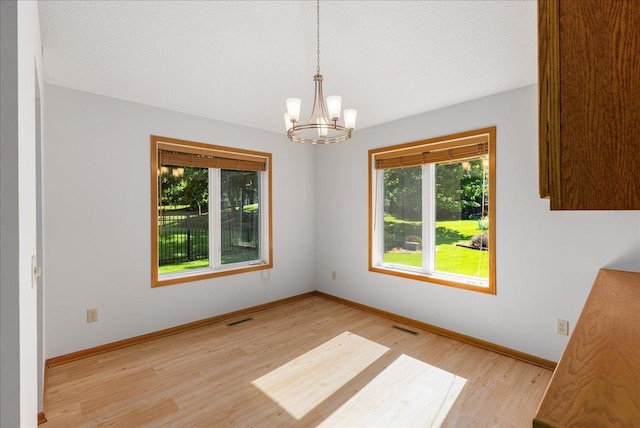 2228 White Pine Ct, Hudson, WI 54016 - unfurnished dining area with a chandelier and light wood-style floors