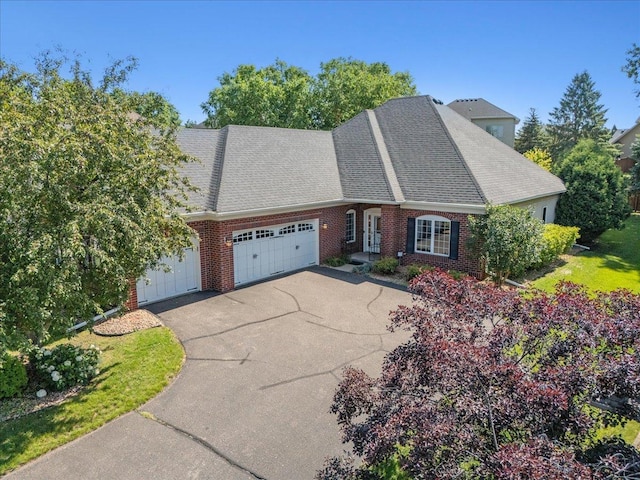 2228 White Pine Ct, Hudson, WI 54016 - view of front of home with a garage, brick siding, driveway, and a shingled roof