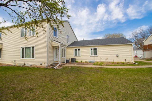 back of house featuring a yard and central air condition unit