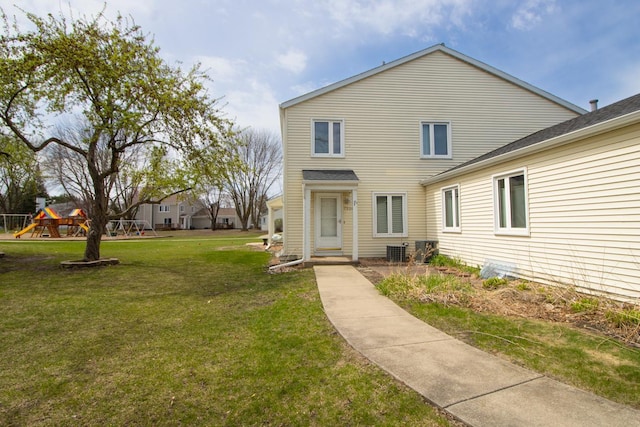 back of property featuring a lawn and central AC unit
