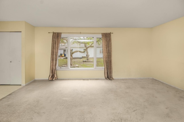 carpeted empty room with visible vents and baseboards