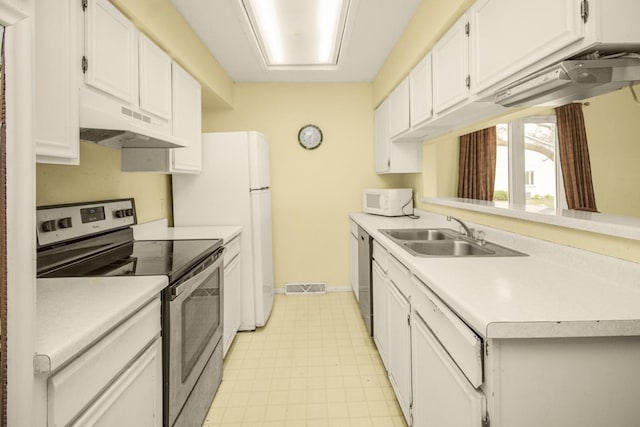 kitchen featuring under cabinet range hood, appliances with stainless steel finishes, light countertops, a sink, and visible vents