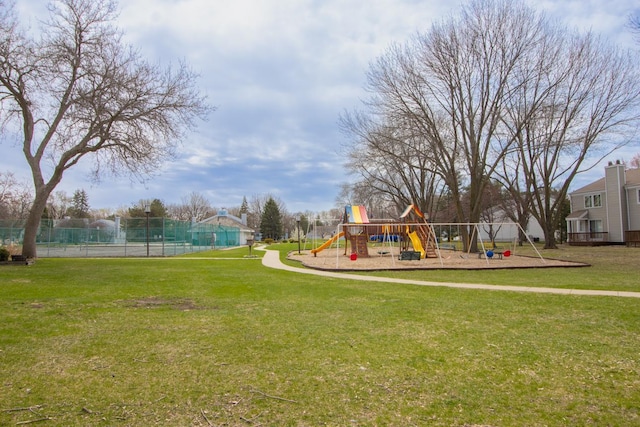 communal playground featuring fence and a lawn