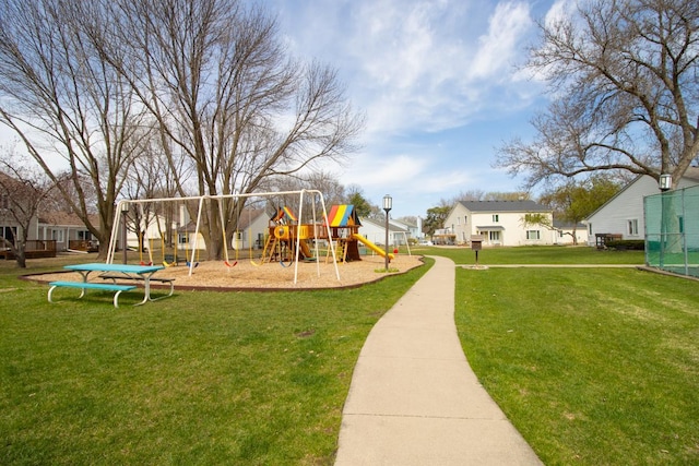 community jungle gym with a residential view and a yard
