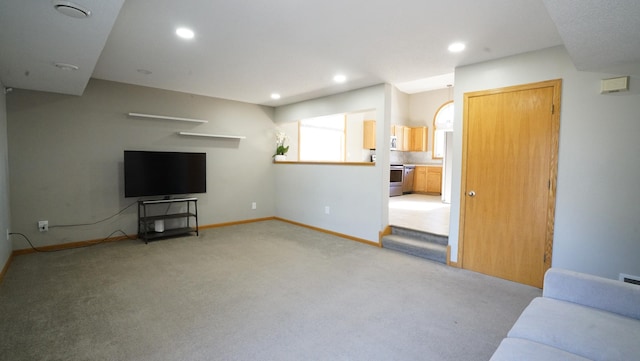 unfurnished living room with baseboards, recessed lighting, and light carpet