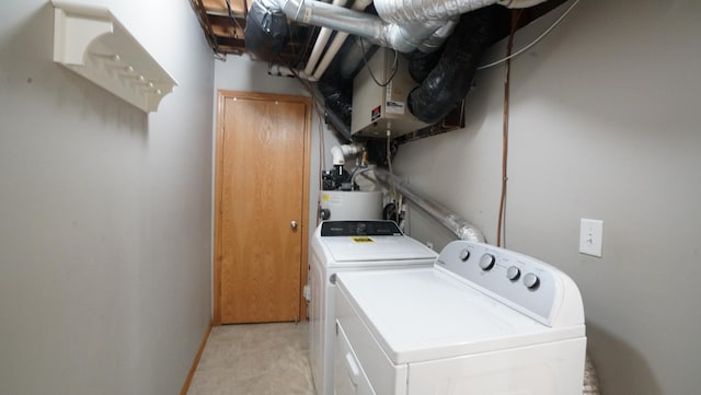 laundry room featuring baseboards, electric water heater, washer and clothes dryer, and laundry area