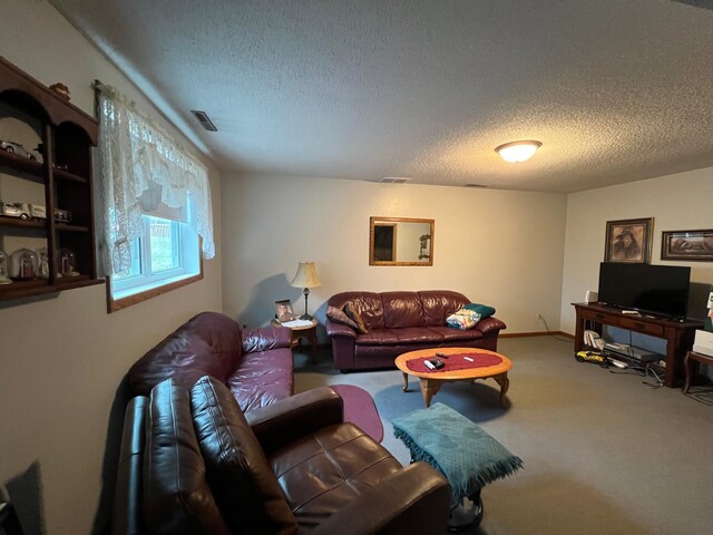 living area with visible vents, carpet floors, and a textured ceiling