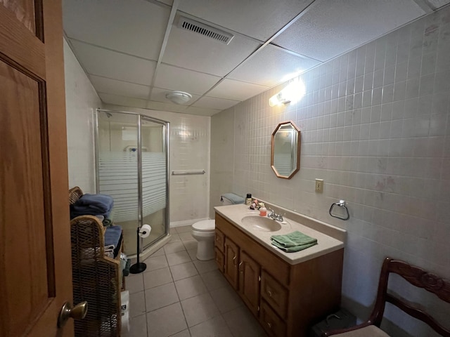 full bathroom with tile walls, a shower stall, vanity, tile patterned floors, and visible vents