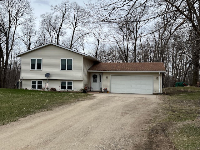 split level home featuring driveway, roof with shingles, a front lawn, and an attached garage