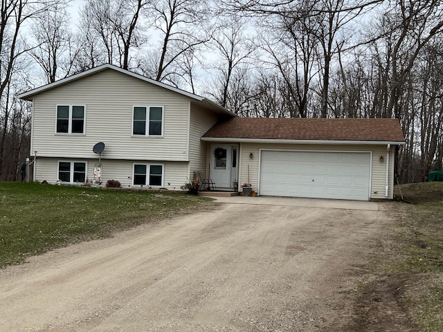 split level home with a front lawn, driveway, a garage, and roof with shingles