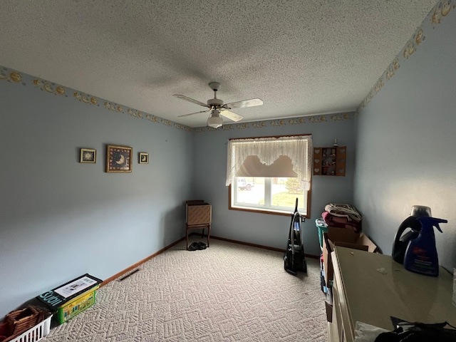 office with a textured ceiling, ceiling fan, light colored carpet, and baseboards