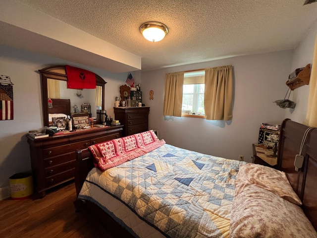 bedroom with a textured ceiling and wood finished floors