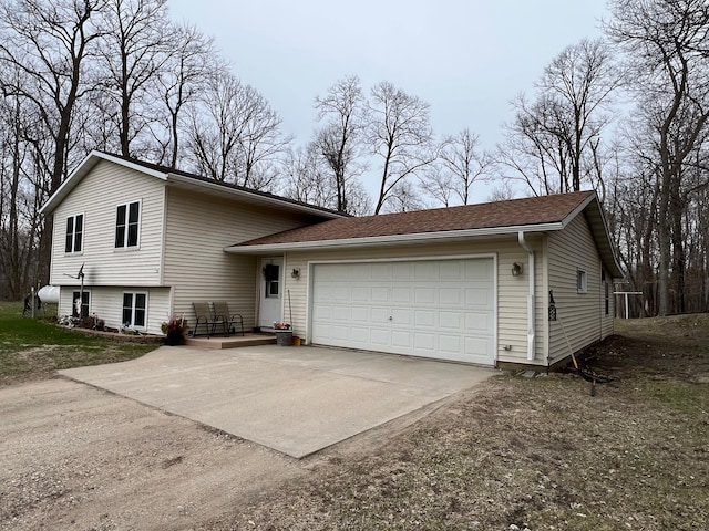 tri-level home with concrete driveway and an attached garage