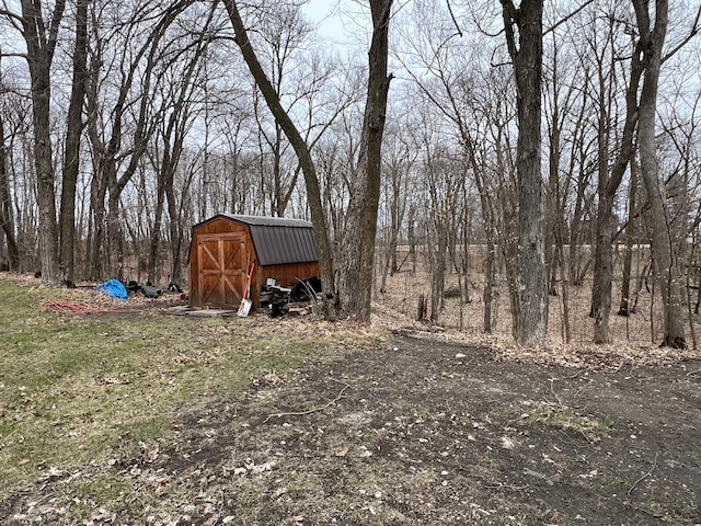 view of yard featuring a storage shed and an outbuilding