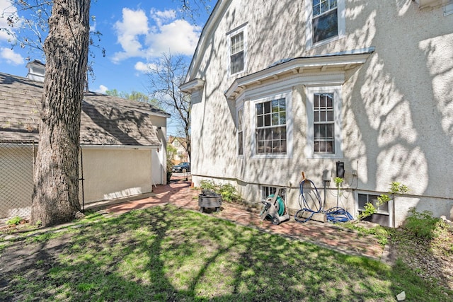 view of side of property featuring stucco siding and a yard