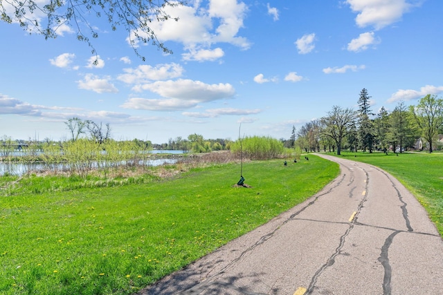 surrounding community featuring a water view and a yard