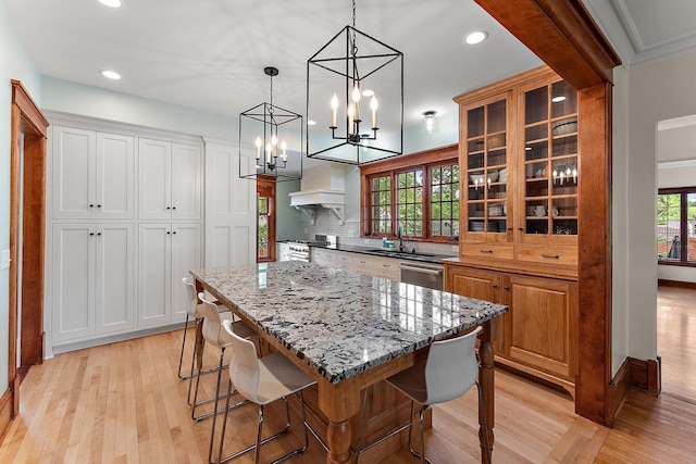 5224 17th Ave S, Minneapolis, MN 55417 - kitchen featuring light wood finished floors, glass insert cabinets, a center island, backsplash, and a kitchen breakfast bar