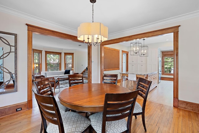 5224 17th Ave S, Minneapolis, MN 55417 - dining area featuring a chandelier, light wood-style flooring, crown molding, and stairway