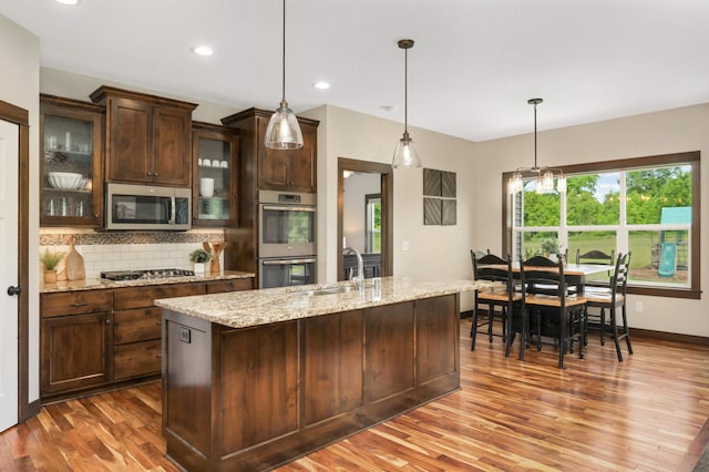 3839 189th Ln NW, Oak Grove, MN 55303 - kitchen featuring stainless steel appliances, a sink, wood finished floors, tasteful backsplash, and dark brown cabinets