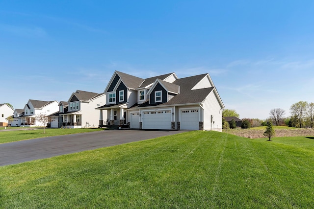 view of front of property featuring a front lawn, driveway, a residential view, and a garage