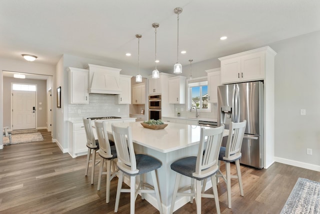 kitchen with stainless steel appliances, premium range hood, backsplash, white cabinets, and recessed lighting