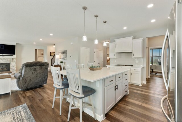 kitchen featuring freestanding refrigerator, custom range hood, dark wood finished floors, white cabinets, and recessed lighting