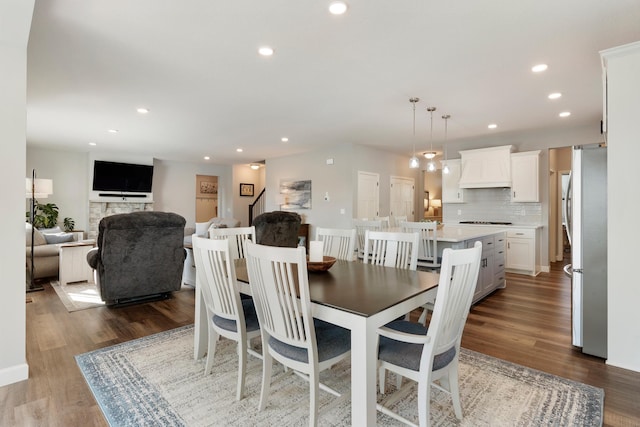 dining space with recessed lighting, wood finished floors, and stairs