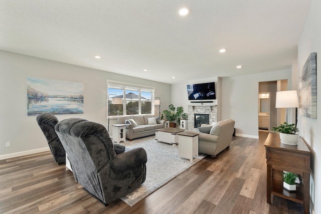 living area featuring wood finished floors, a fireplace, baseboards, and recessed lighting