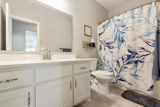 bathroom with toilet, vanity, tile patterned flooring, and a shower with shower curtain