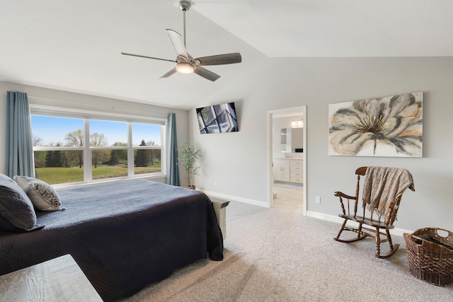 carpeted bedroom featuring vaulted ceiling, ensuite bath, baseboards, and ceiling fan
